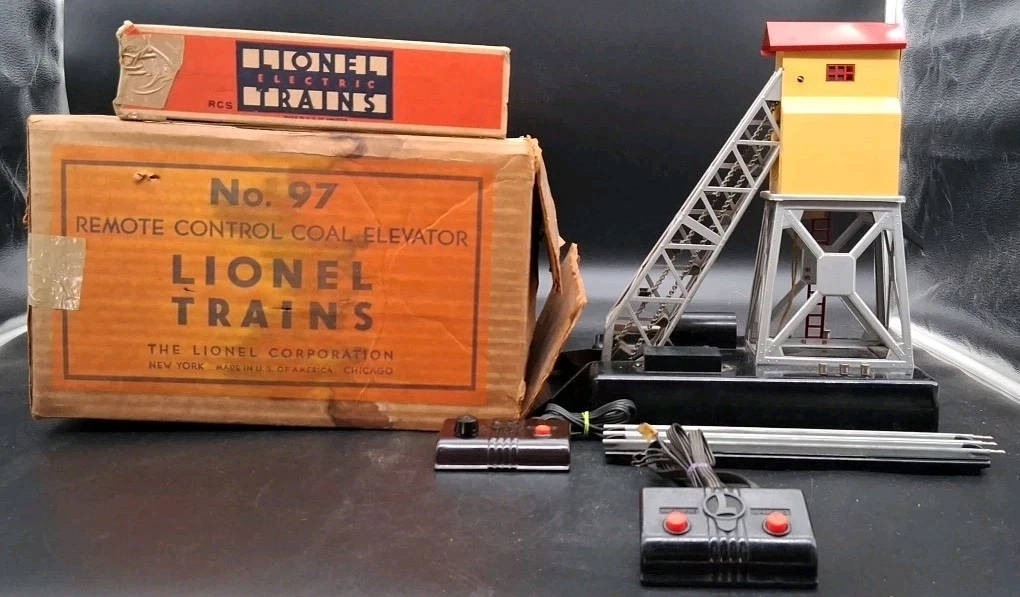 Le chargeur de charbon (Coal Tipple / Coal Loader no. 97) : Un grand classique d'après-guerre. Une grue ou une rampe déversait de petites billes de bakélite noire (imitant le charbon) directement dans un wagon trémie (hopper car)